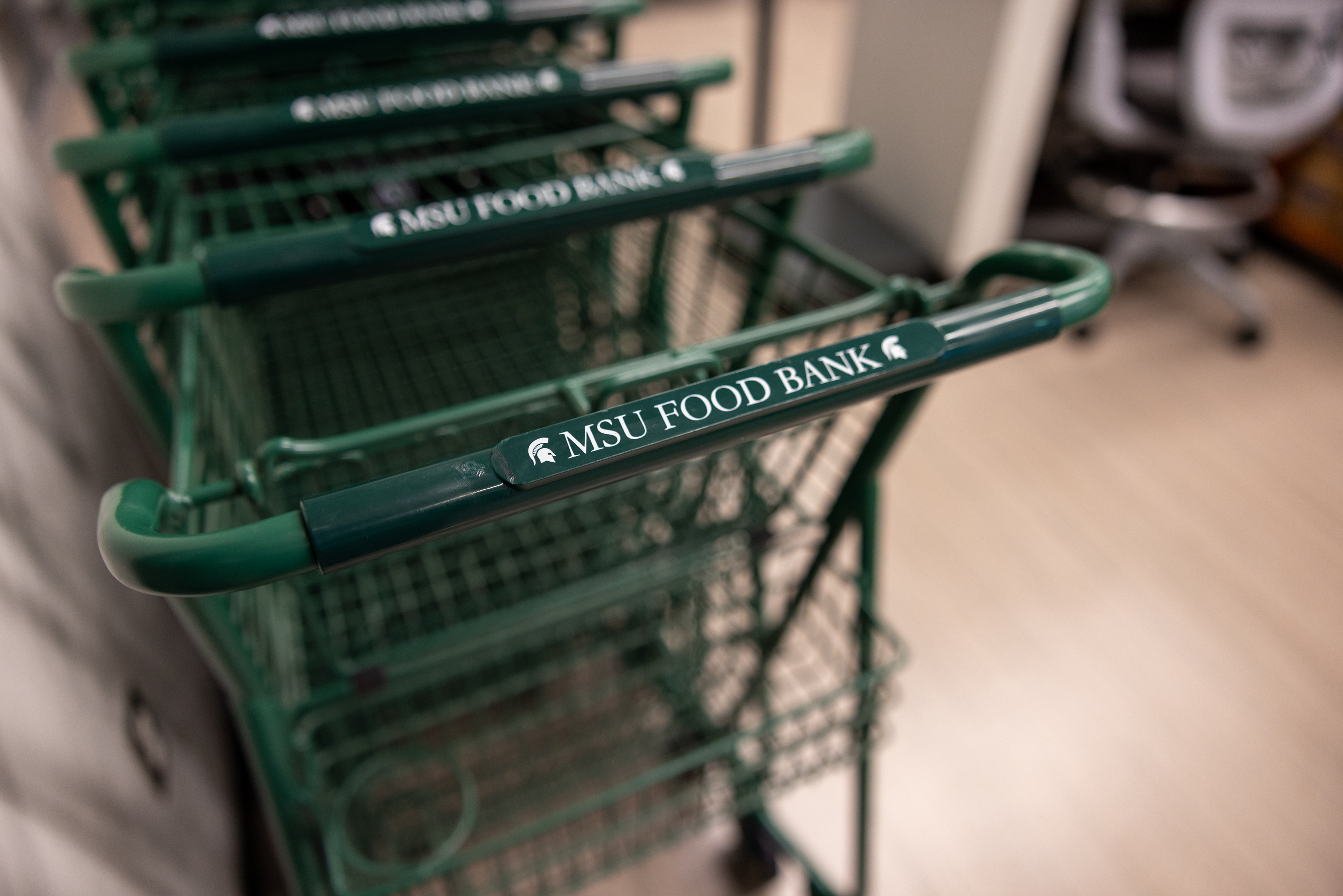 green shopping cart with "msu food bank" on the handle bar