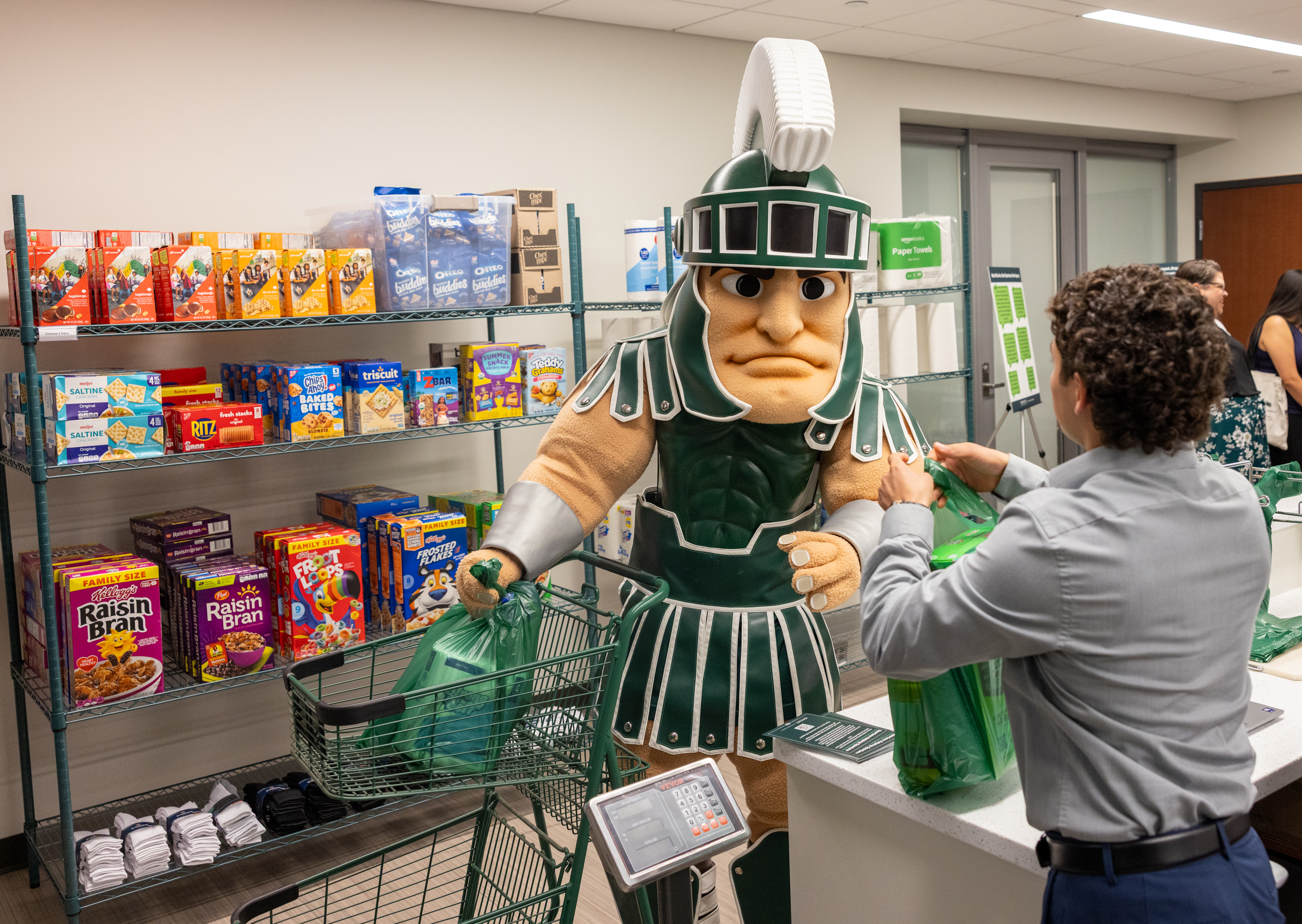 Sparty mascot checking out at Spartan Shelf