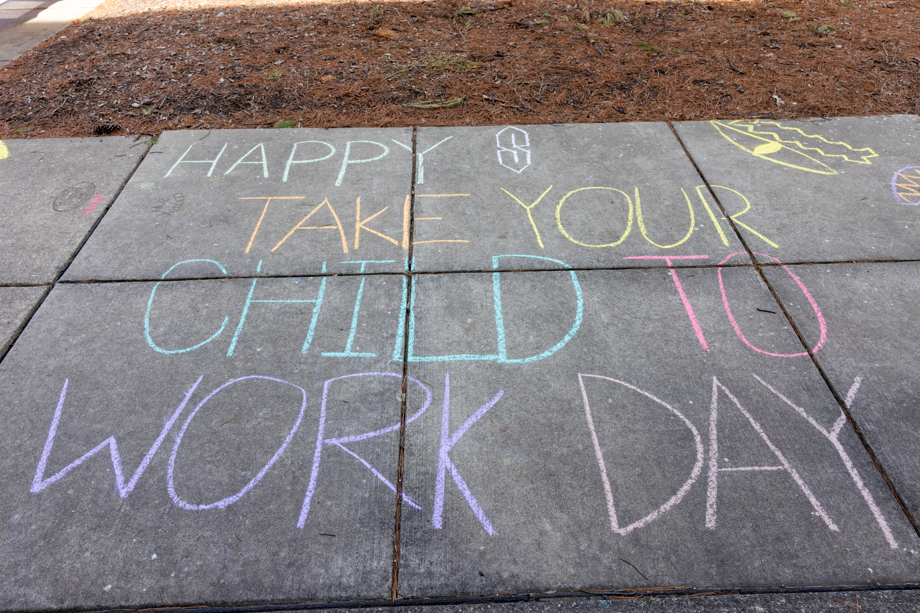 sidewalk chalk that reads "happy take your child to work day"
