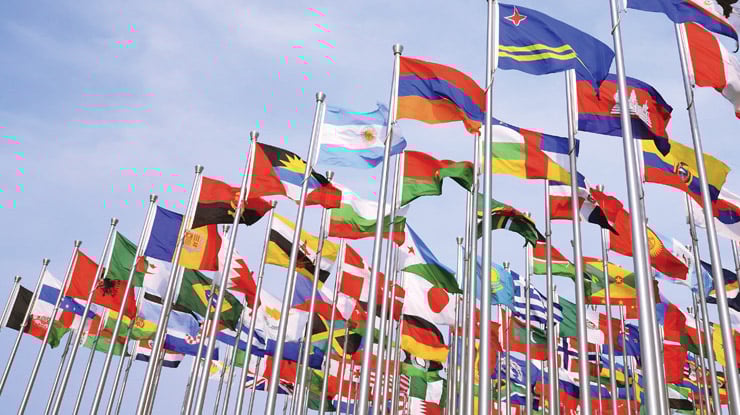 A visual representation of global studies as the flags of all of the countries in the world, flying high with bright colors.