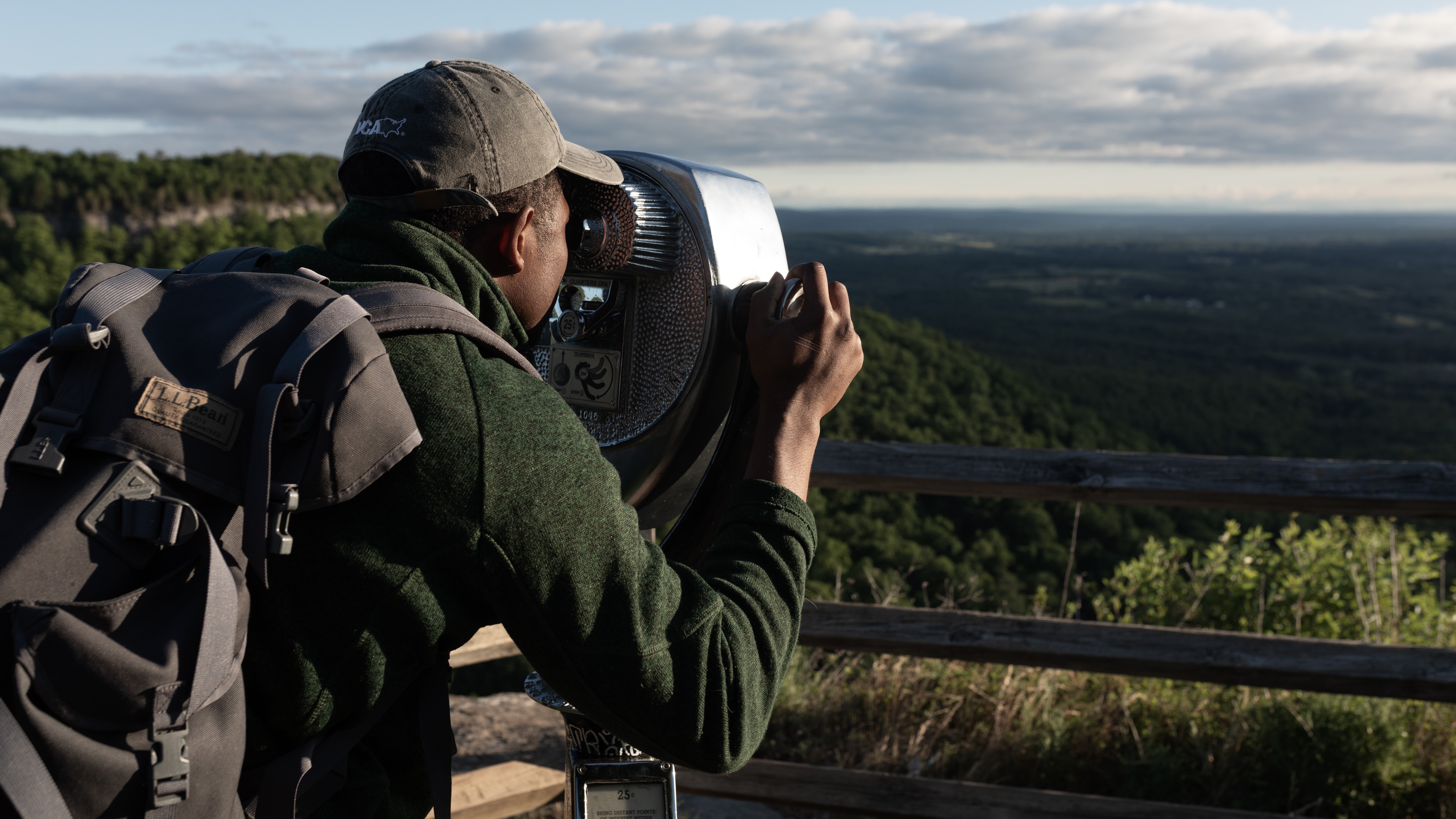 An MSU student working toward a tourism degree helps visitors in a park.