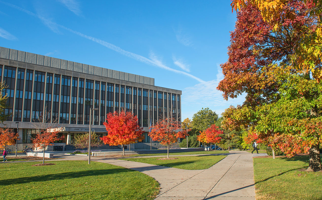 The Hannah Administration building on a sunny day surrounded by trees with red and green leaves.