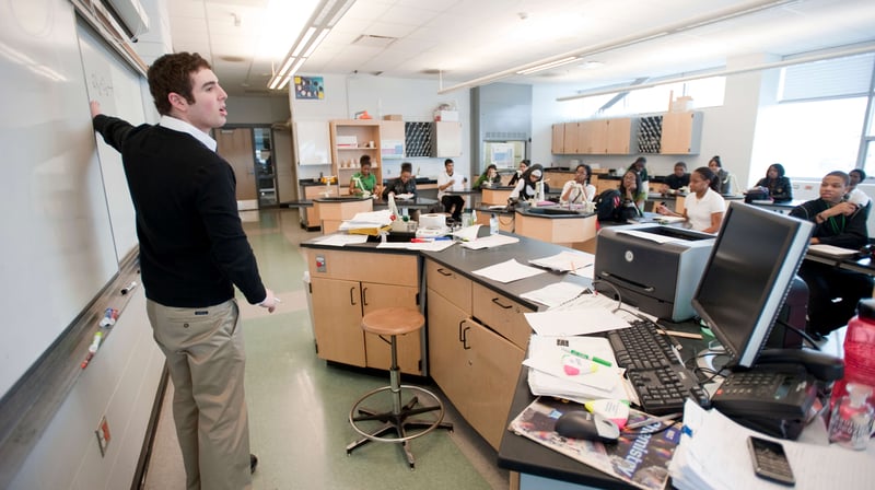 A professor motions to a whiteboard as he lectures to a classroom about return on investment at MSU.