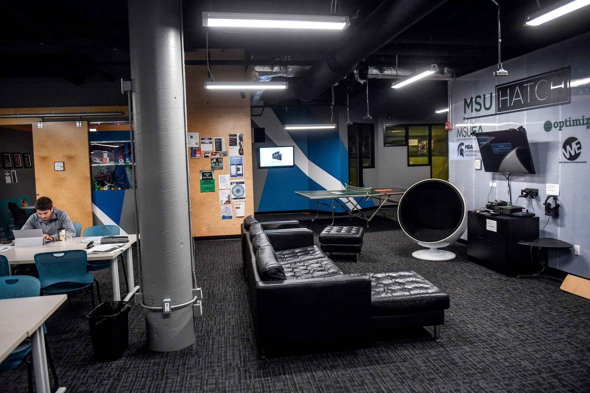 Room with lounge areas, technology, and tables.