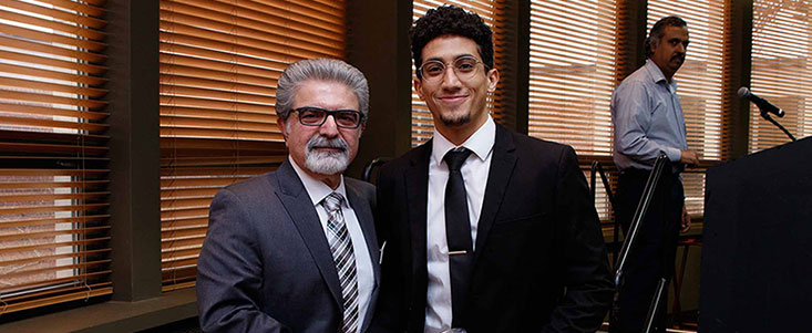 Smiling Chairperson Abdol-Hossein Esfahanian standing next to a Computer Science and Engineering Alumni at the Fall 2019 Grad Breakfast event. 