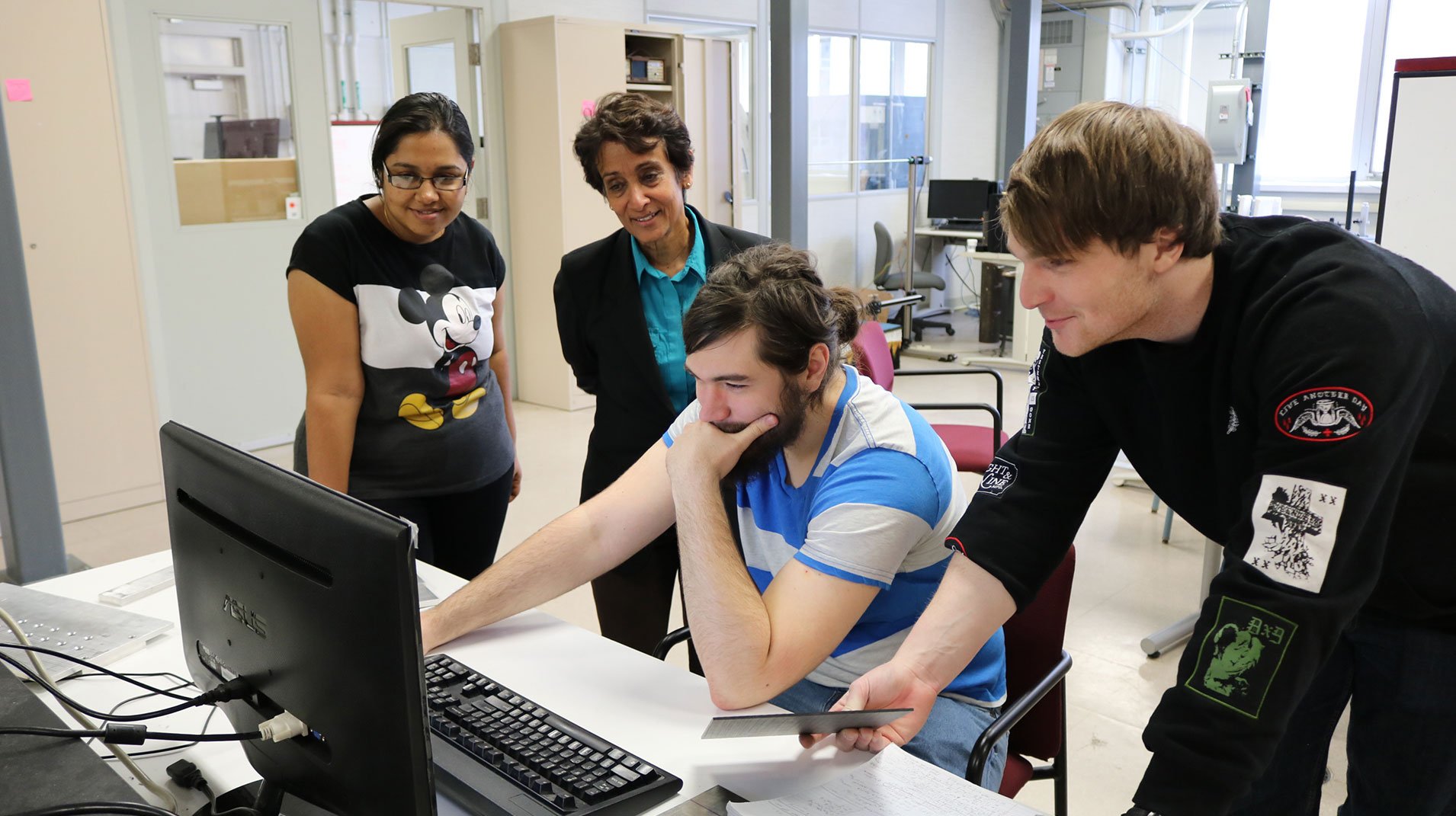 Students and professor all staring at a computer