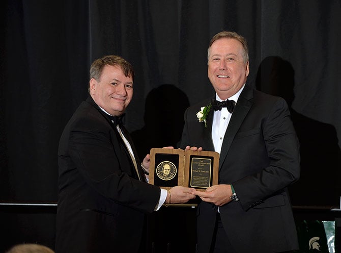 Michael W. Lamach Sr. accepting the 2022 Alumni Award from Dean Kempel