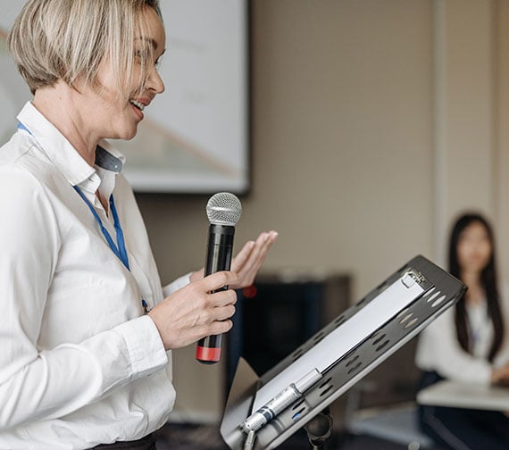 Individual speaking at a podium during an event.
