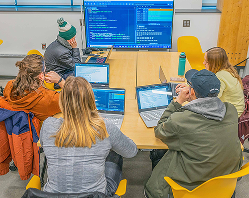 Students in an introduction to programming class review code on a monitor in the STEM Teaching and Learning Facility. Photo by Derrick Turner.