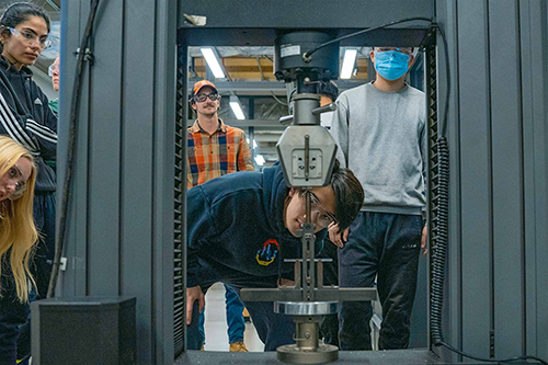 During a materials science and engineering class, students conduct a three-point bending experiment to measure the strength of glass. Photo by Annie Barker.