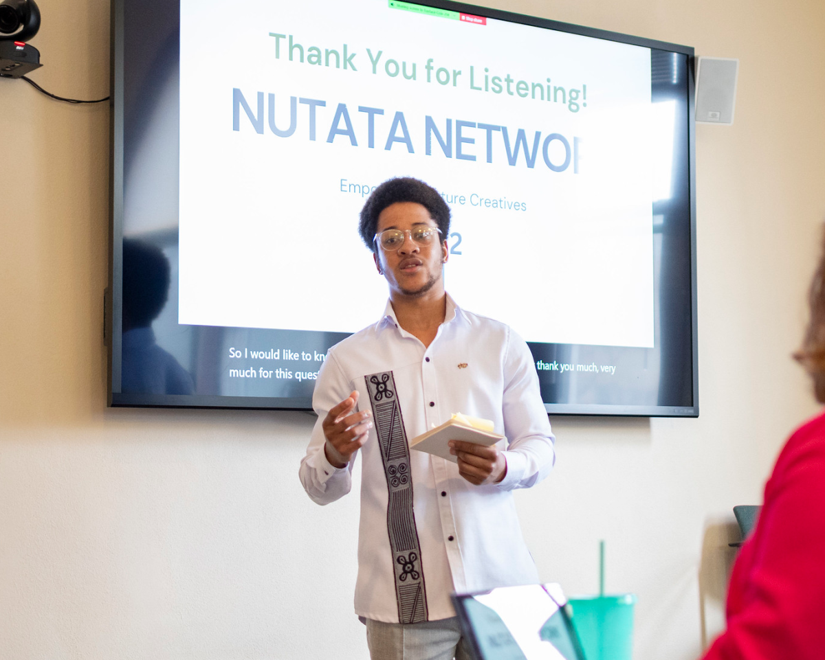 Man speaking in front of a screen that reads Nutata Network.