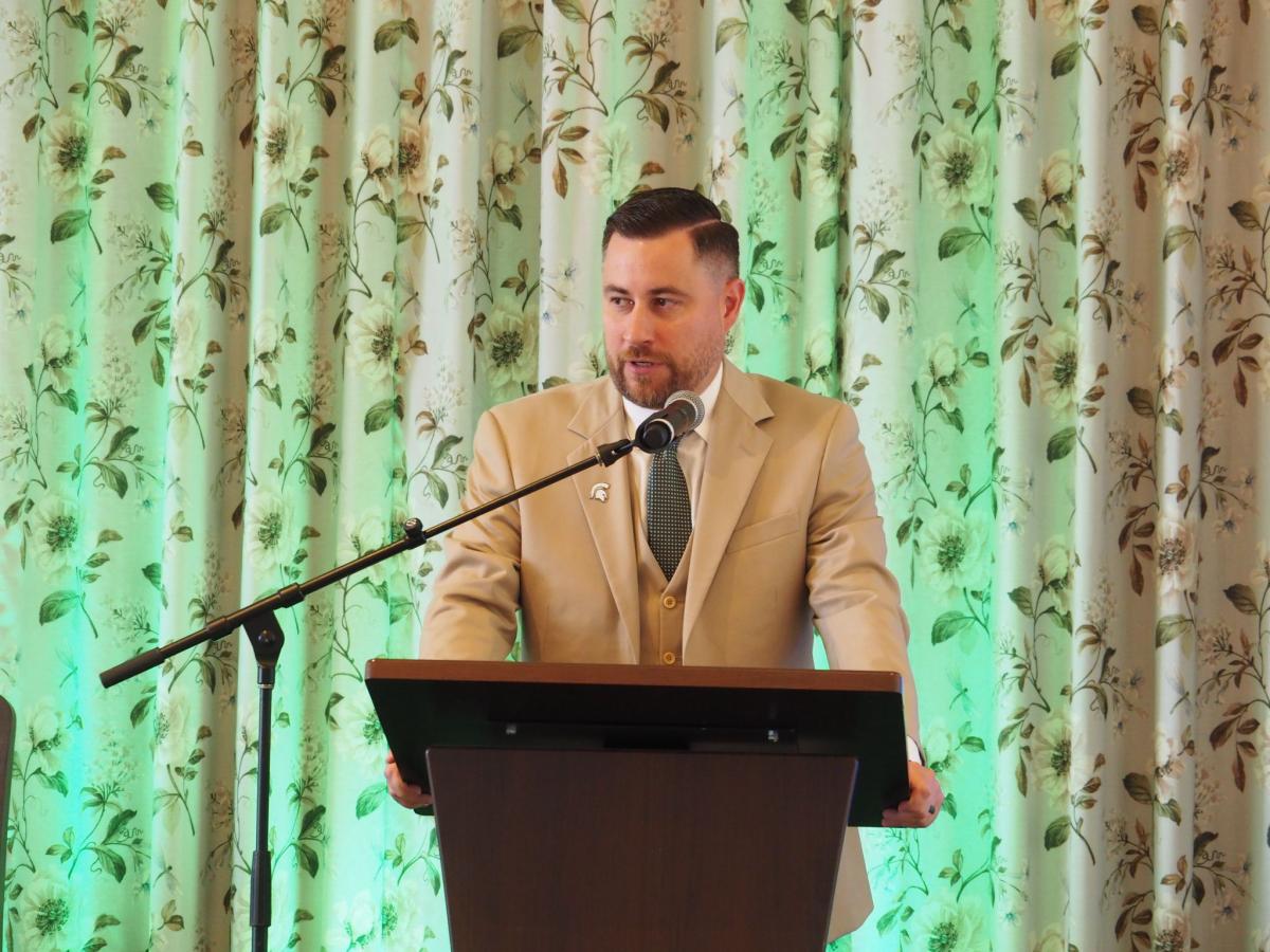 Judd Herzer speaks at a podium