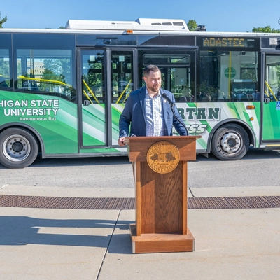 Person speaks at a podium on the SpartanXpress inauguration