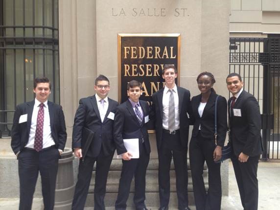 Group of students in suits outside the Federal Reserve Building.