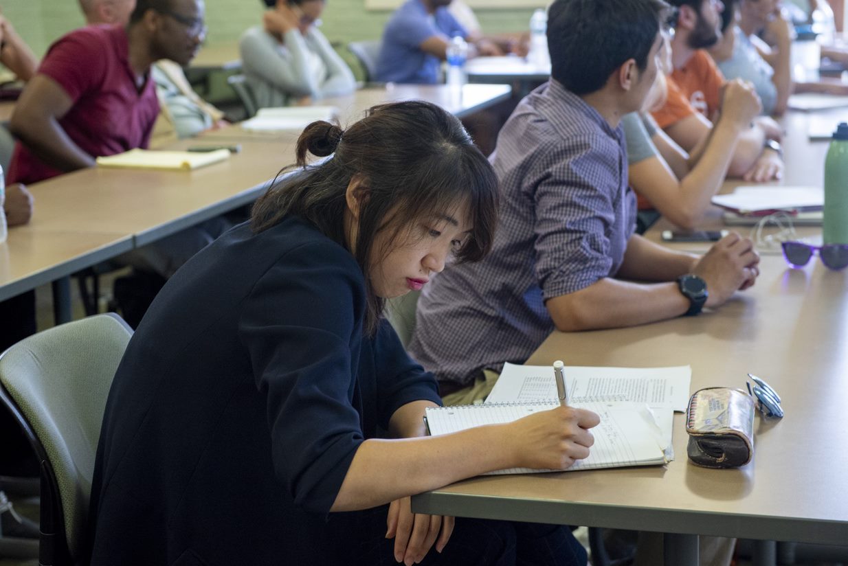 Female student taking notes in class. 