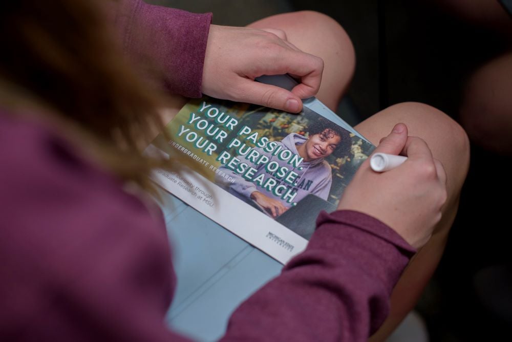 Student holds brochure in advising appointment. 