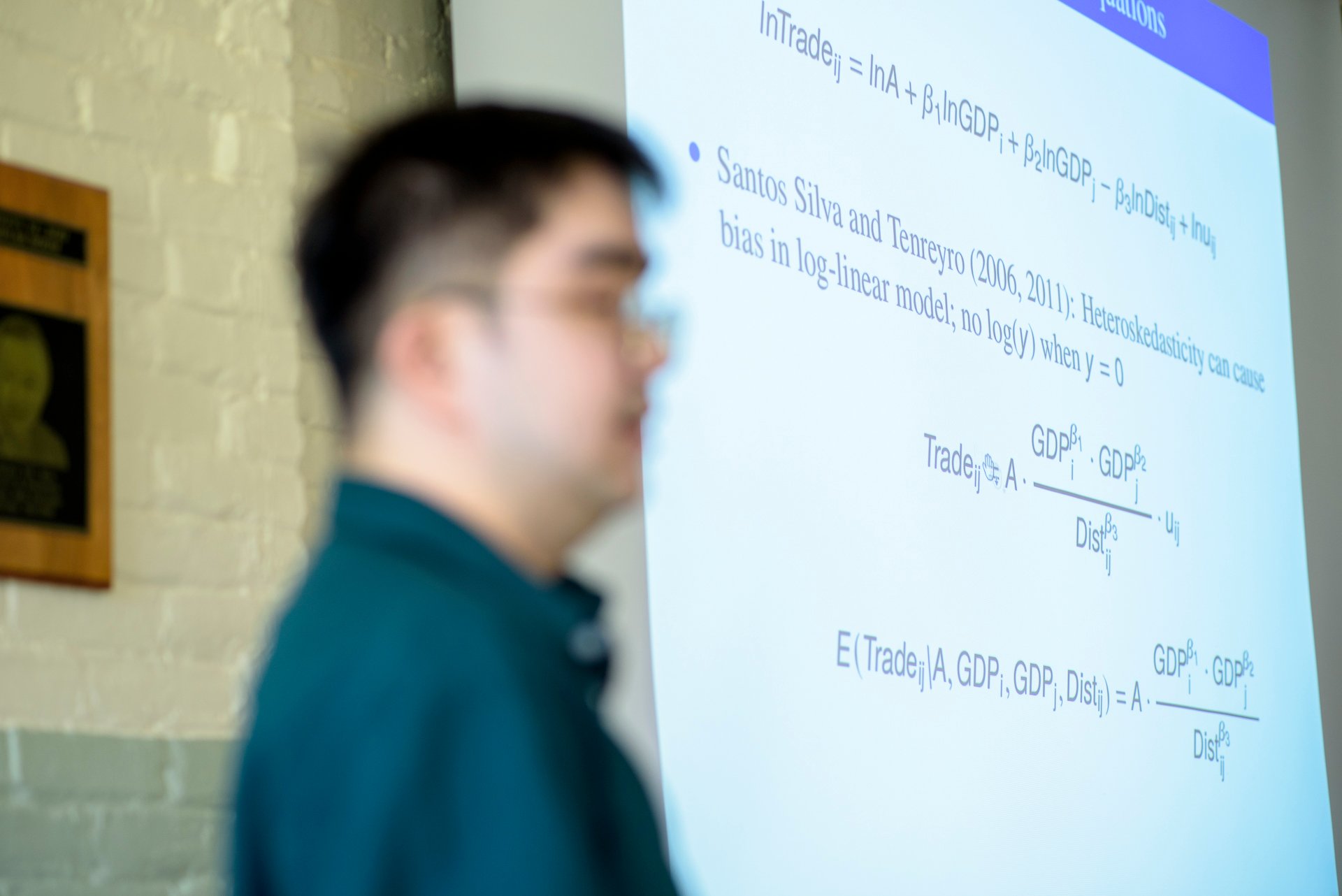 A person presents a slide on a projector.
