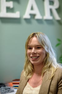 Sierra Smith smiles in front of a pile of LEGO bricks.