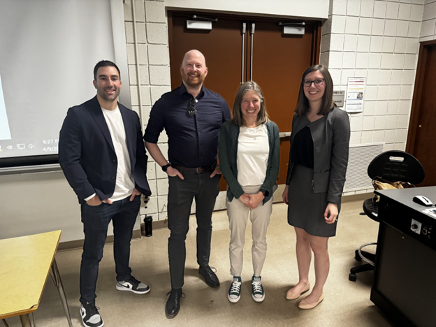 Men and women standing in a classroom. 