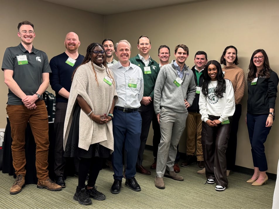 All the MSU Economics alumni standing together and smiling.
