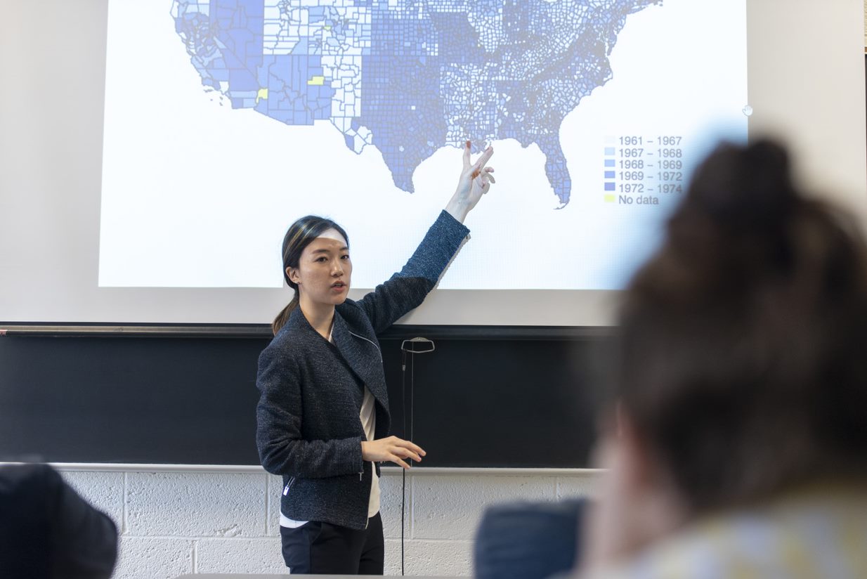 MSU Professor teaches in front of classroom with U.S. PowerPoint slide on the screen.