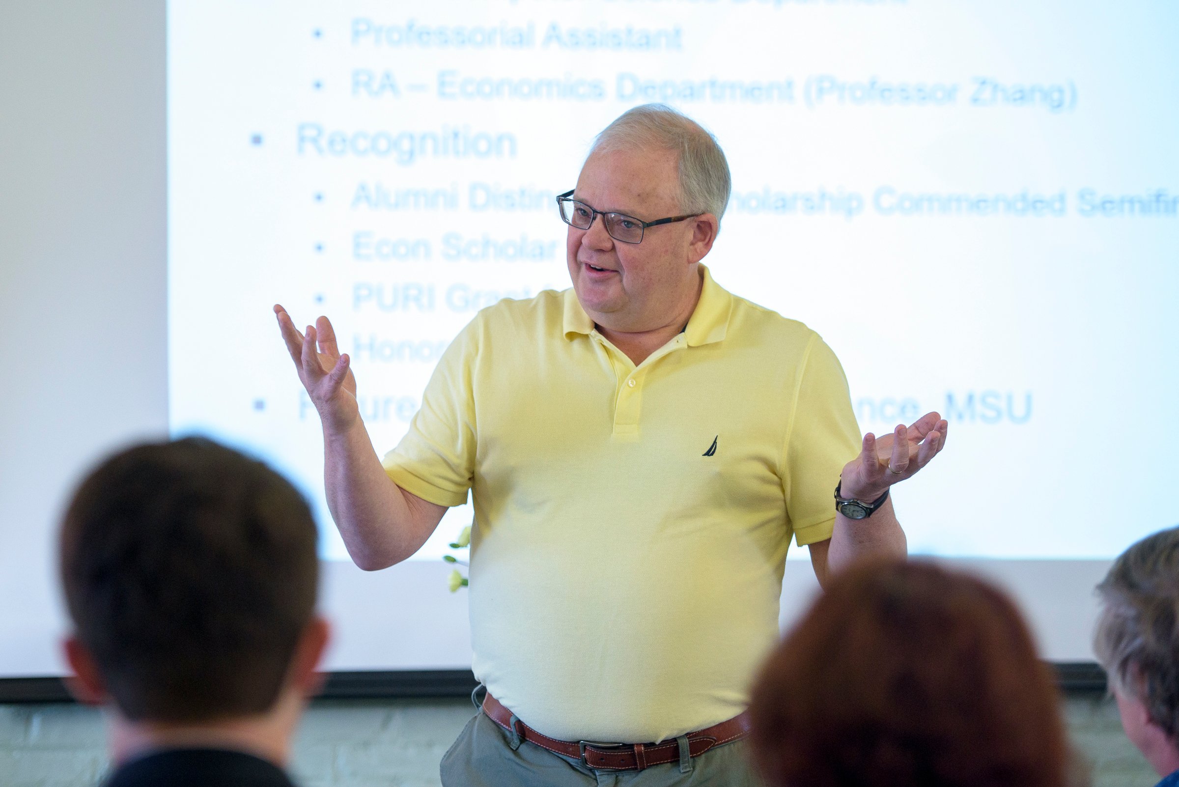 Professor speaks in front of a classroom.