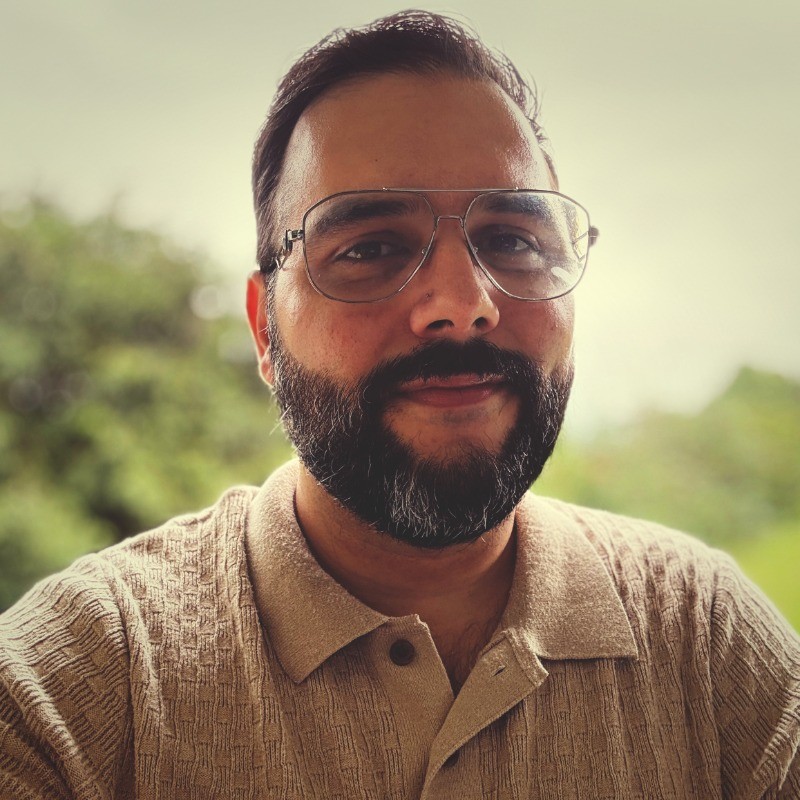 This is a photo of Rolando. He has short, dark brown hair, a mustache and beard, and is wearing glasses.