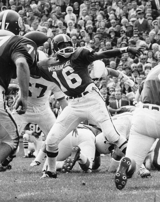 Historic image of a football game in action, showing players mid-play.