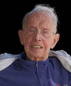 Portrait of an older man with short white hair, wearing a jacket and smiling slightly.