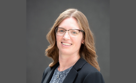 A headshot of Sara Witmer. She is smiling and wearing a black sport coat.