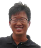 This is a headshot of David Wong. David has short, dark brown hair, medium skin, and wears glasses. He is smiling at the camera. He is wearing a dark brown collared shirt. The background is plain white.