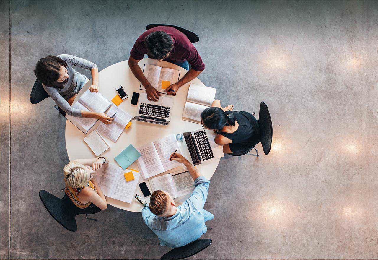 Students gather around a circular table in study