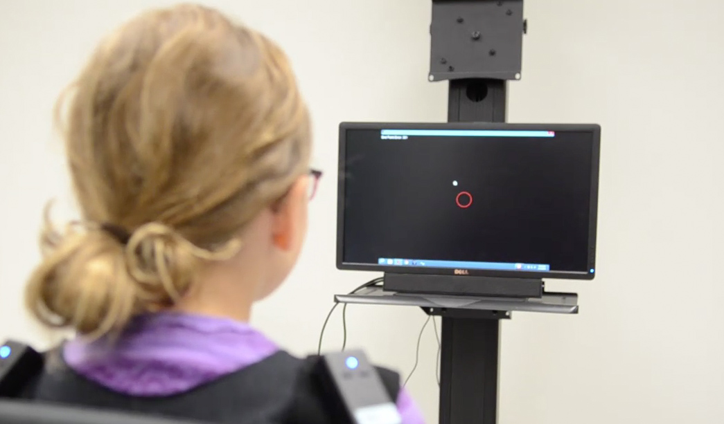 A young child interacts with a computer during a Kinesiology lab experiment