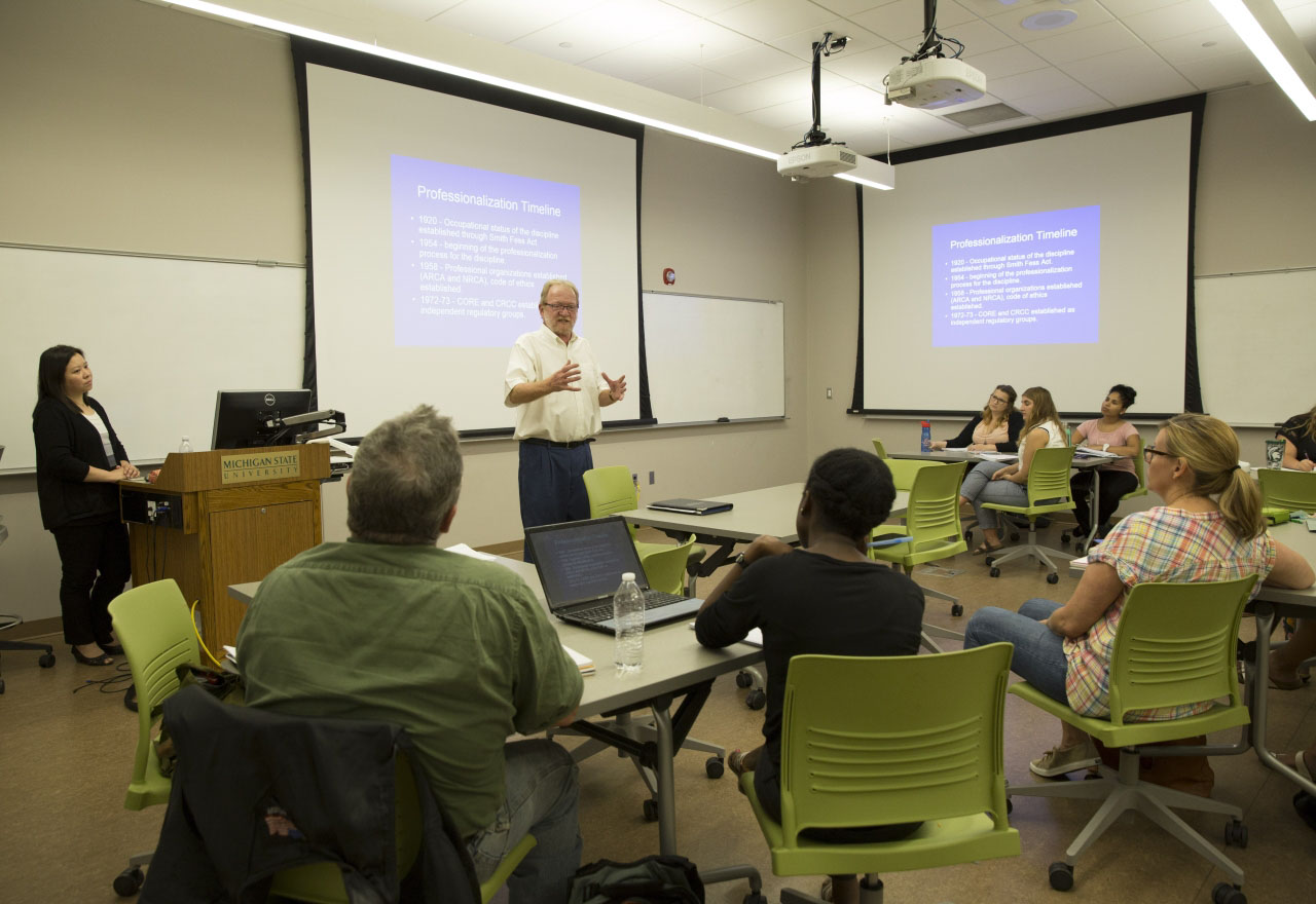 MSU faculty stand at the front of a full classroom