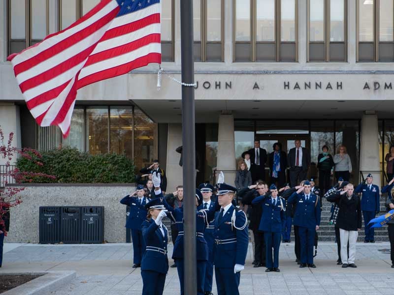 ROTC students salute during a flag ceremony in front of the Hannah administration building
