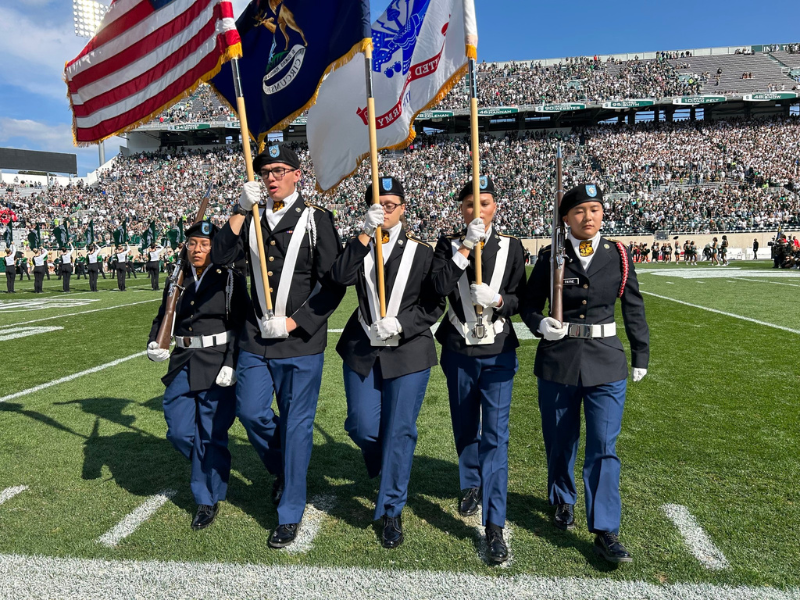 ROTC members with flags on football field