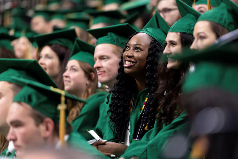 MSU graduates in green caps and gowns. 
