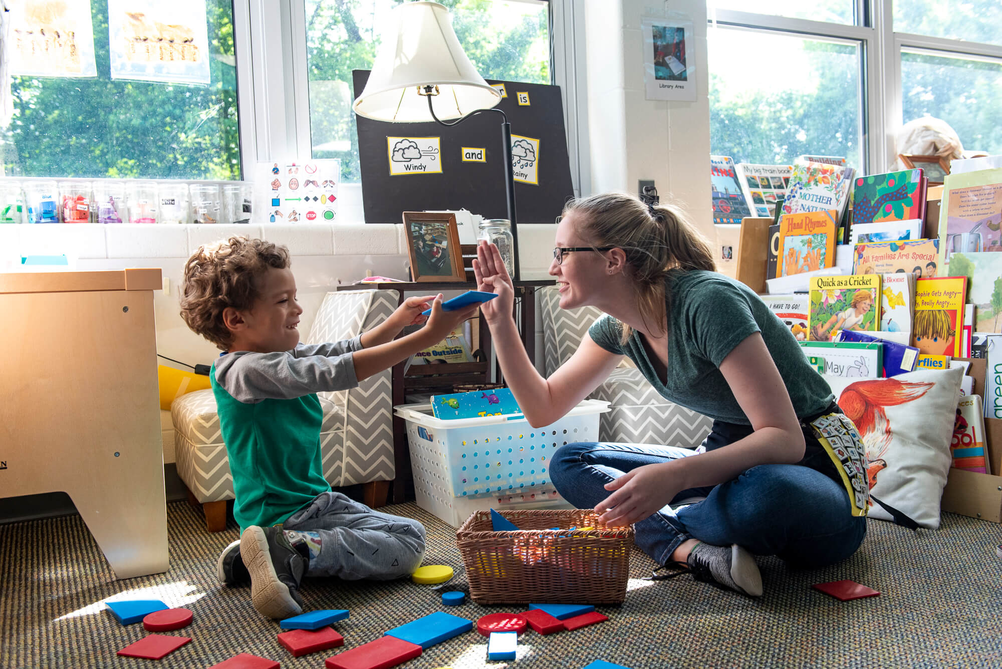 A teacher plays with a kid.