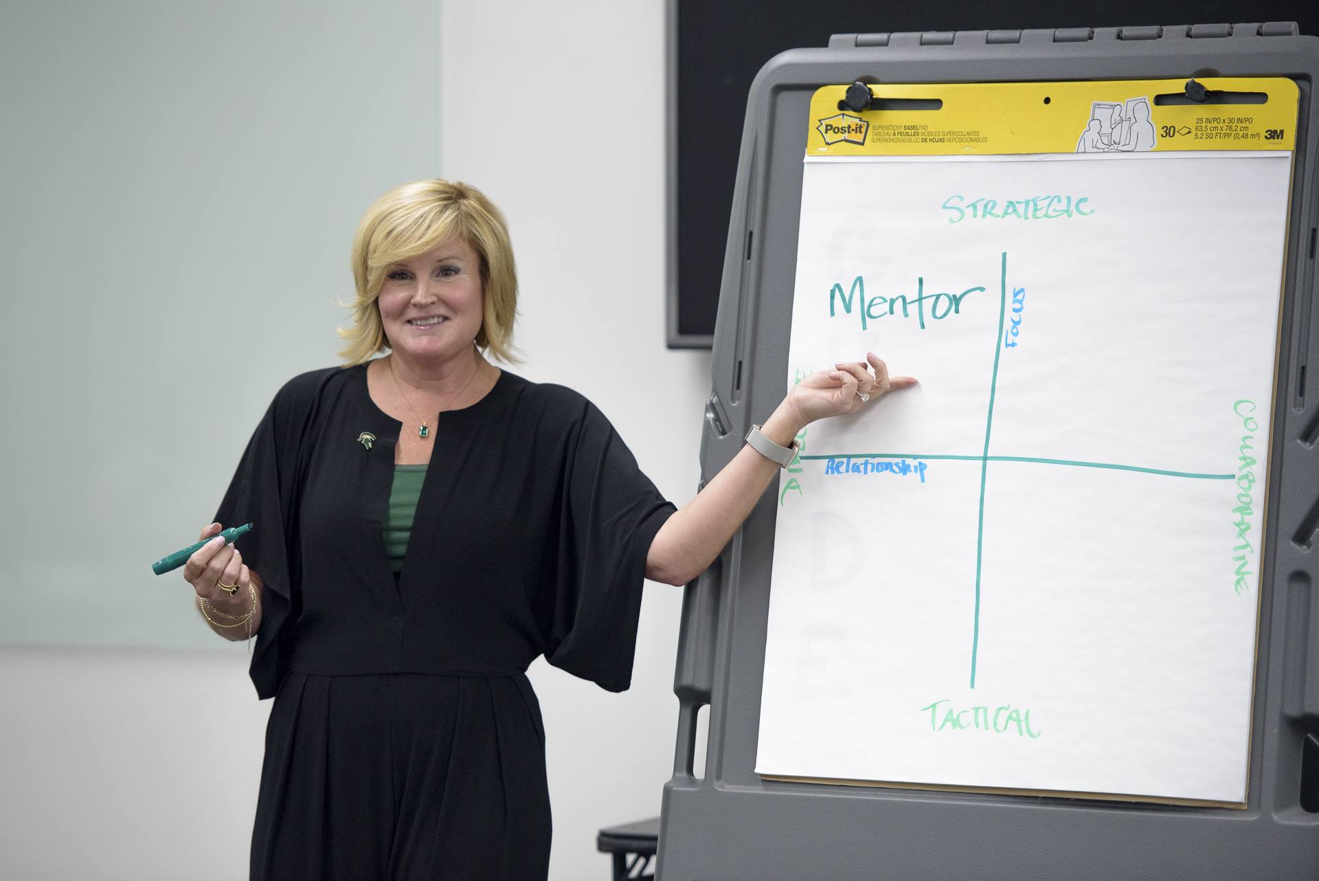 A woman points to a board that reads mentorship.