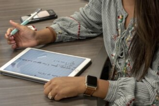 Woman takes notes on ipad.