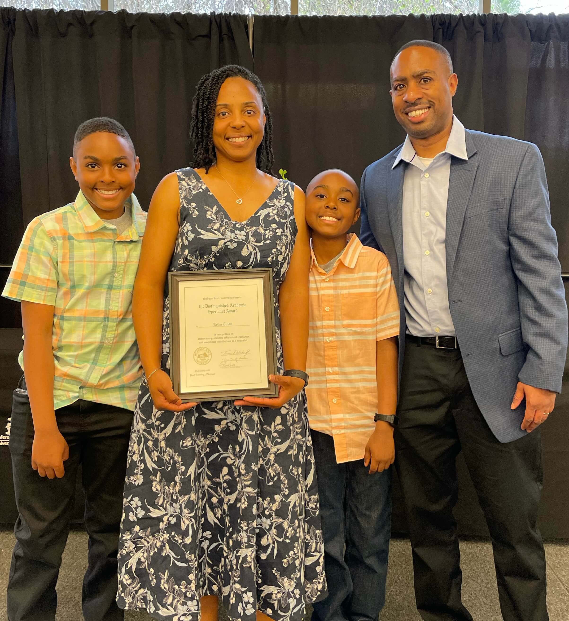 Colon with her husband, sons and award. 
