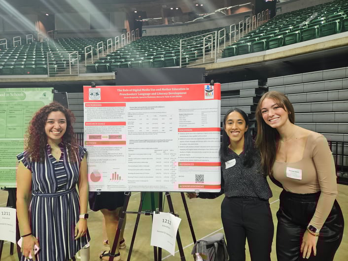 Women with a research poster.