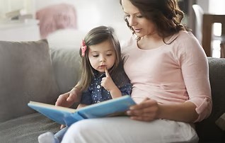 Two year old and adult reading.