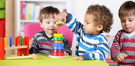 Two year olds playing with blocks.