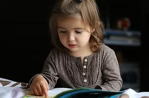 A three year old reading a book.