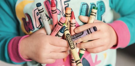 A three year old with crayons.