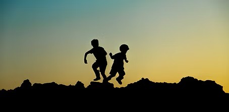 Sillouettes of children playing during sunset. 