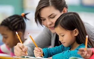 Four year olds writing with an adult supporting.