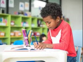 A five year old reads a book.