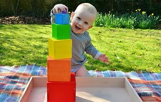 Nine month old playing with blocks.